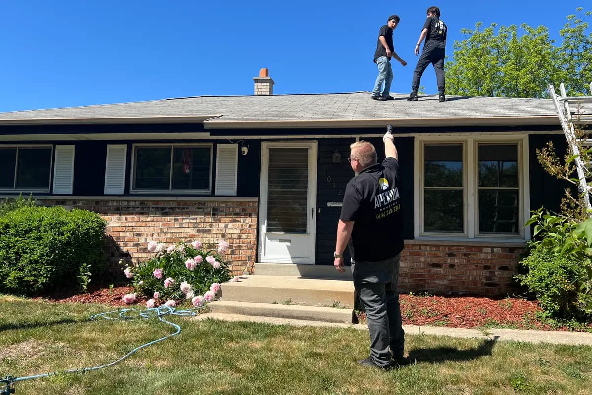 Apexium Roofing inspecting the roofline of a Bayside, WI home from the front walk
