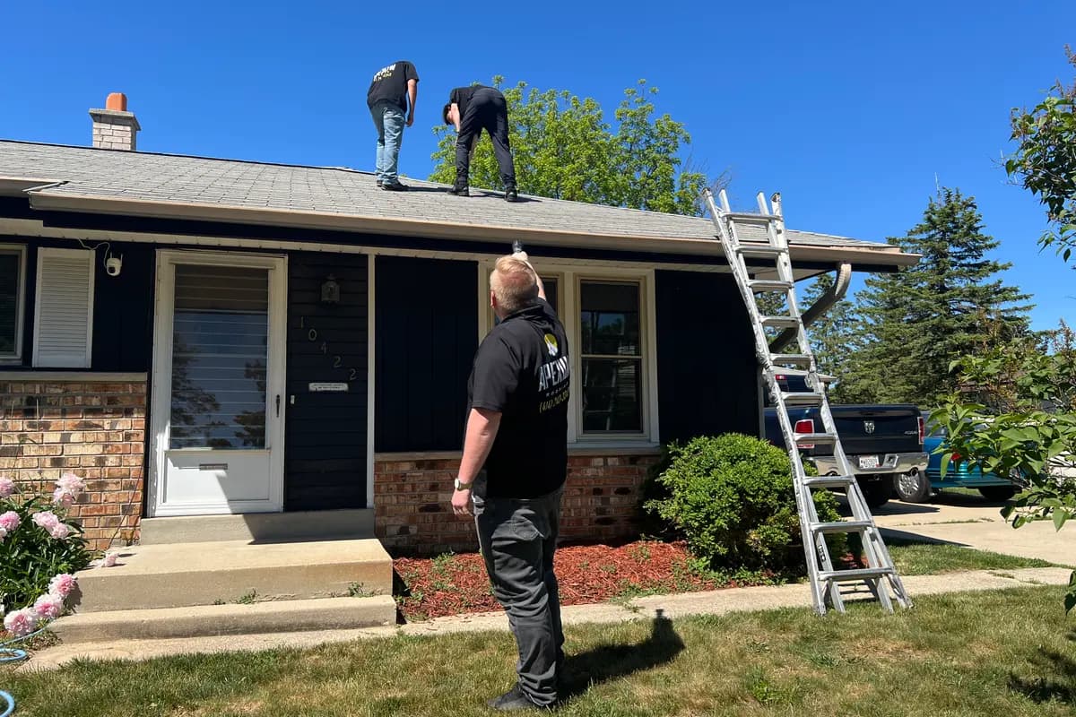 Apexium Roofing crew working along the ridge of a Fox Point, WI home