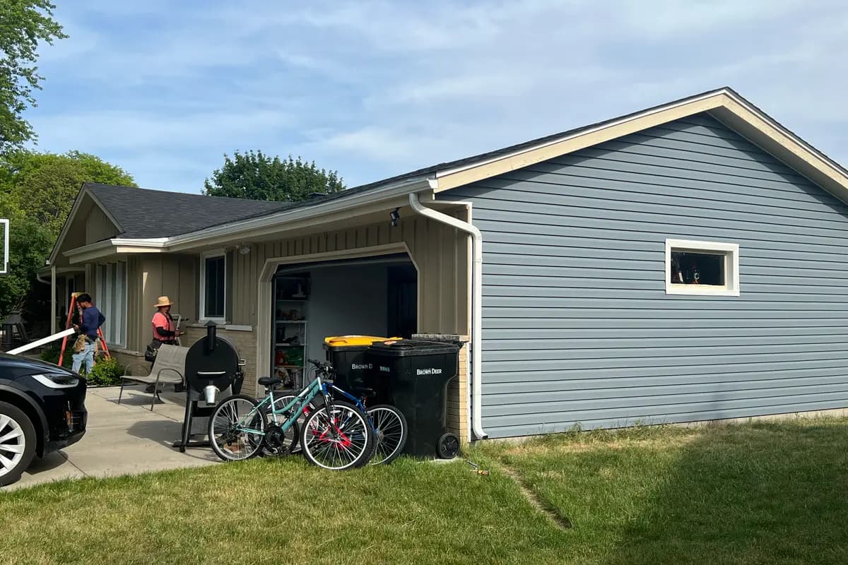 Apexium Roofing crew working at a Sussex, WI home with materials staged in the open garage