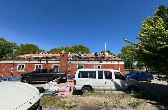 Apexium Roofing crew and dump trailer on a storm damage job in Grafton, WI